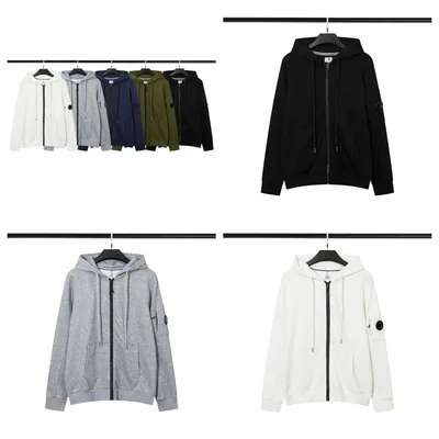 Sudaderas con capucha y cremallera colgadas en perchas, en blanco, gris y negro
