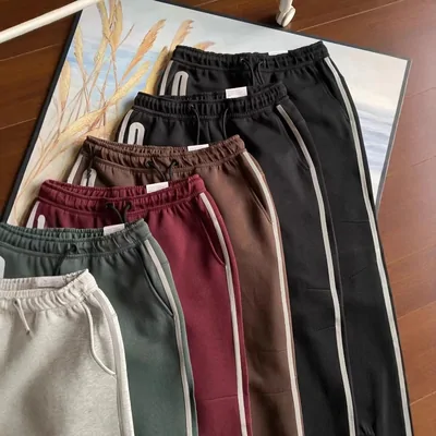 Pantalones de chándal negros, verdes, beige y granates colgados