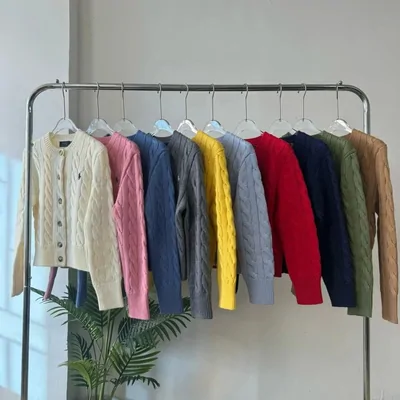 Chaquetas de punto de colores colgadas en un burro de ropa